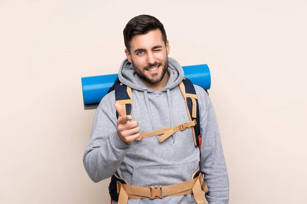 Junger Bergsteiger Mit Großem Rucksack Über Isoliertem Hintergrund Zeigt Mit — Stockfoto