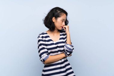 Asyalı genç kadın soyutlanmış mavi arka planda kuşkuları var