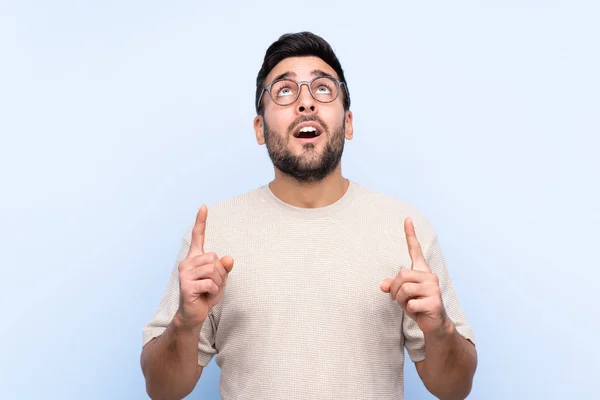 Jovem Homem Bonito Com Barba Sobre Fundo Azul Isolado Apontando — Fotografia de Stock