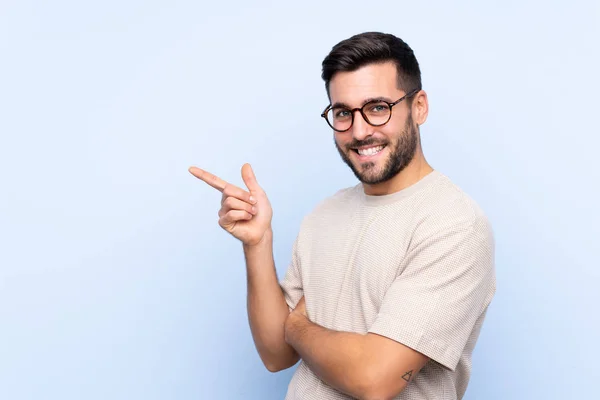 Jonge Knappe Man Met Baard Geïsoleerde Blauwe Achtergrond Wijzende Vinger — Stockfoto