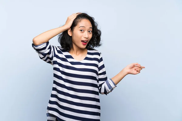 Asyalı Genç Bir Kadın Soyutlanmış Mavi Arka Planda Şaşırmış Işaret — Stok fotoğraf