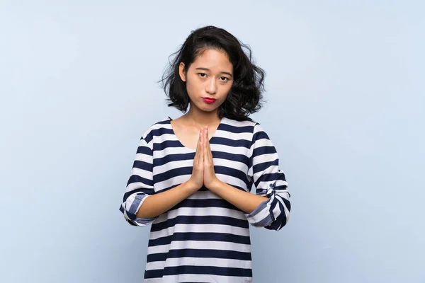 Asiatisk Ung Kvinna Över Isolerad Blå Bakgrund Håller Handflatan Samman — Stockfoto