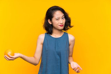 Asyalı genç kadın bir portakal tutan