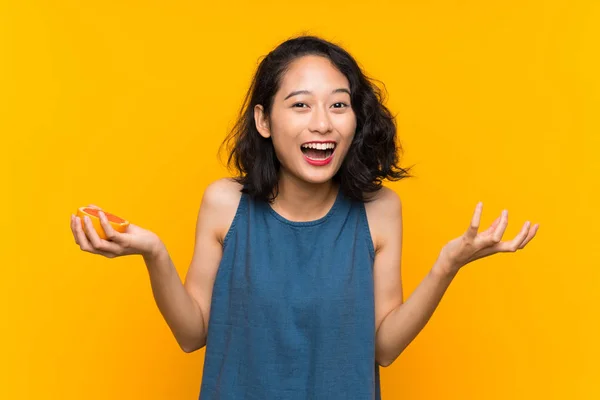 Ung Asiatisk Flicka Som Håller Grapefrukt Över Isolerad Orange Bakgrund — Stockfoto