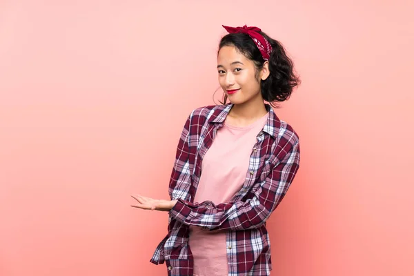 Asiatische Junge Frau Auf Isoliertem Rosa Hintergrund Präsentiert Eine Idee — Stockfoto