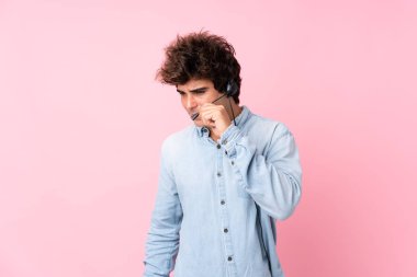 Tecrit edilmiş pembe geçmişi olan genç beyaz bir adam kulaklıkla çalışıyor.