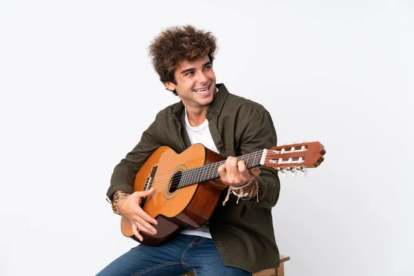 Junger kaukasischer Mann mit Gitarre vor isoliertem weißem Hintergrund — Stockfoto