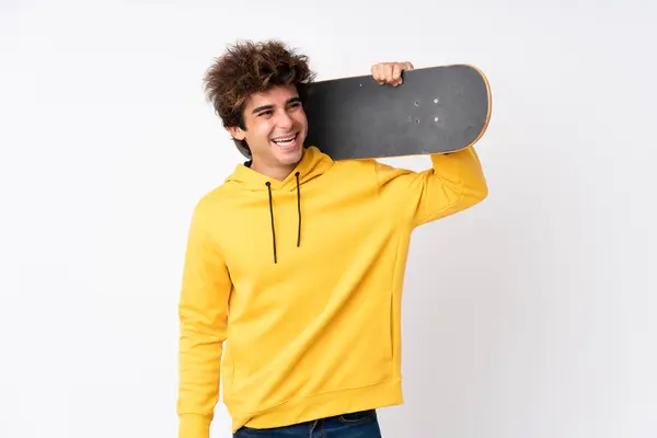 Schöner junger Skater-Mann über isolierte weiße Mauer — Stockfoto