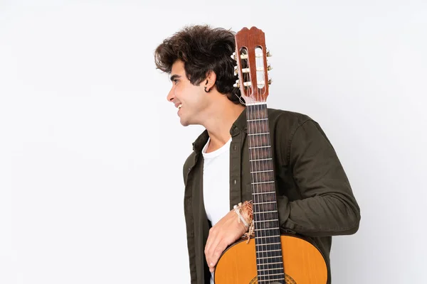 Giovane uomo caucasico con chitarra su sfondo bianco isolato — Foto Stock