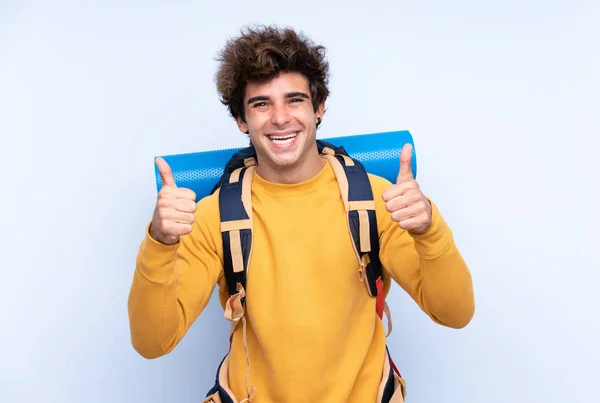 Jovem Montanhista Homem Com Uma Grande Mochila Sobre Fundo Azul — Fotografia de Stock