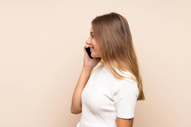 Soyutlanmış bir geçmişi olan genç sarışın bir kadın cep telefonuyla sohbet ediyor.