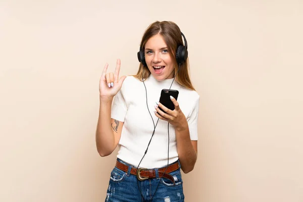 Młoda Blondynka Odizolowanym Tle Pomocą Telefonu Komórkowego Słuchawkami Śpiewem — Zdjęcie stockowe