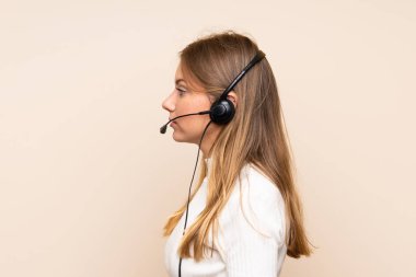 Tecrit edilmiş genç sarışın kadın kulaklıkla çalışıyor.