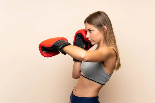 Jong blond meisje met bokshandschoenen over geïsoleerde achtergrond — Stockfoto