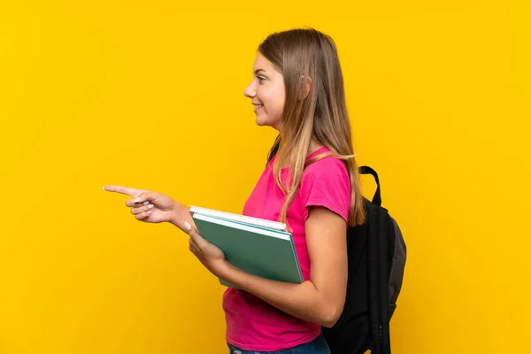 Junges Studentenmädchen Über Isoliertem Gelben Hintergrund Der Zur Seite Zeigt — Stockfoto