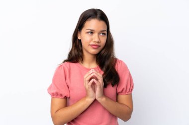 Genç Kolombiyalı kız izole edilmiş beyaz arka plan entrikaları çeviriyor.