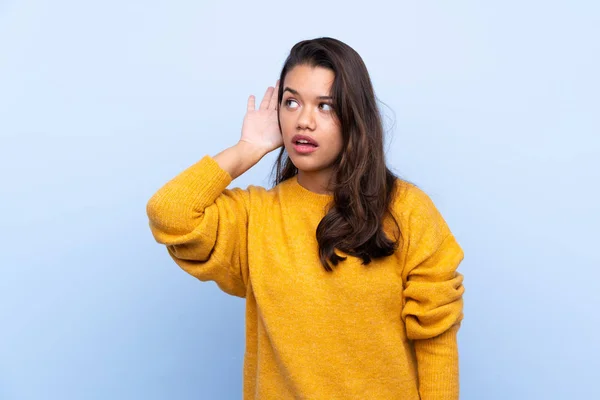 Jovem Colombiana Com Suéter Sobre Fundo Azul Isolado Ouvindo Algo — Fotografia de Stock