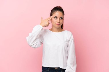 Soyutlanmış pembe arka planda genç esmer kız intihar jesti yapmada sorun yaşıyor.