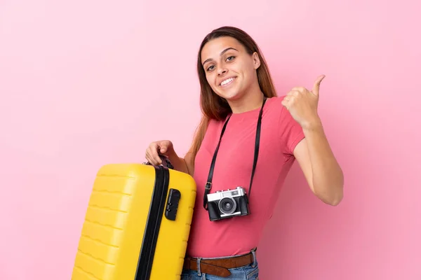 Teenager Cestovatel Dívka Drží Kufr Přes Izolované Růžové Pozadí Ukazuje — Stock fotografie