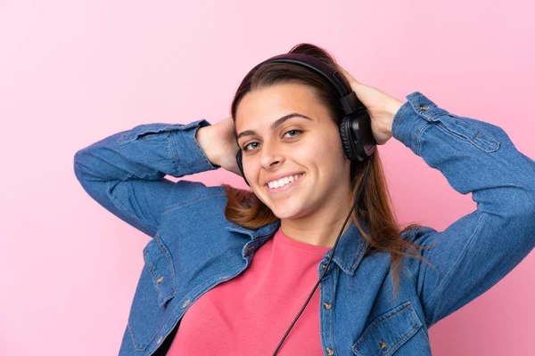 Ragazza adolescente ascoltando musica oltre isolato muro rosa — Foto Stock