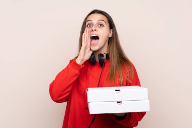Pizza dağıtan kız izole olmuş duvarda pizza tutuyor ve ağzı açık bağırıyor.