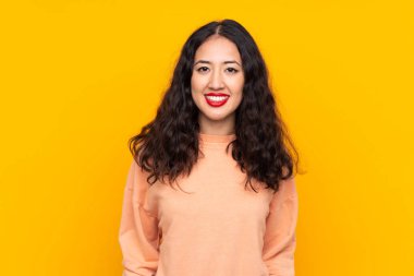 İspanyol Çinli kadın izole edilmiş sarı arka planda gülüyor.