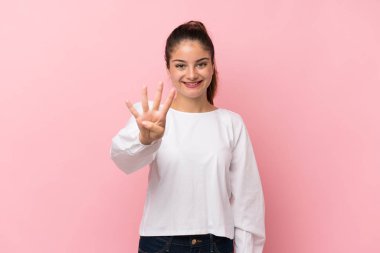 Genç esmer kız pembe arka planda mutlu ve parmaklarıyla dörde kadar sayıyor.