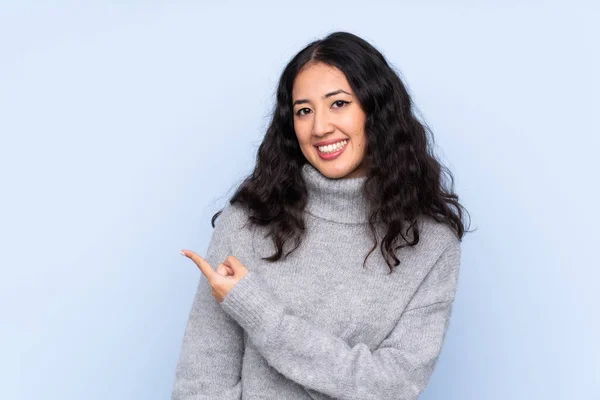 Spaanse Chinese Vrouw Geïsoleerde Blauwe Achtergrond Wijzend Terug — Stockfoto