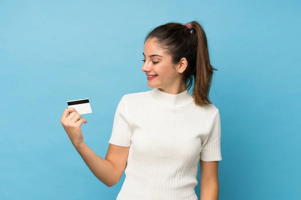 Jovem Morena Sobre Fundo Azul Isolado Segurando Cartão Crédito — Fotografia de Stock