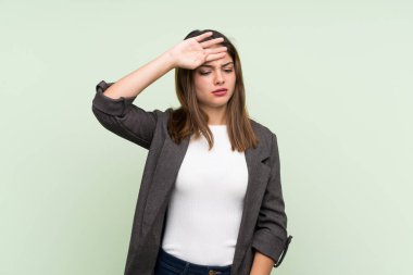 Spor ceketli genç esmer kız izole edilmiş yeşil arka plan, yorgun ve hasta bir yüz ifadesi var.