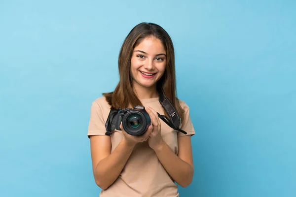 Молодая Брюнетка Изолированном Синем Фоне Профессиональной Камерой — стоковое фото