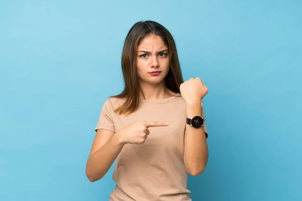 Joven Morena Sobre Fondo Azul Aislado Mostrando Reloj Mano Con — Foto de Stock