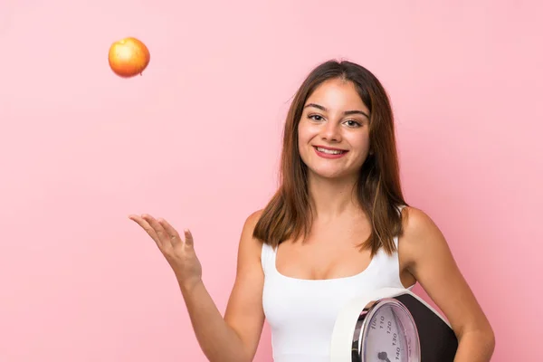 Ung söt flicka med våg maskin och med ett äpple över i — Stockfoto