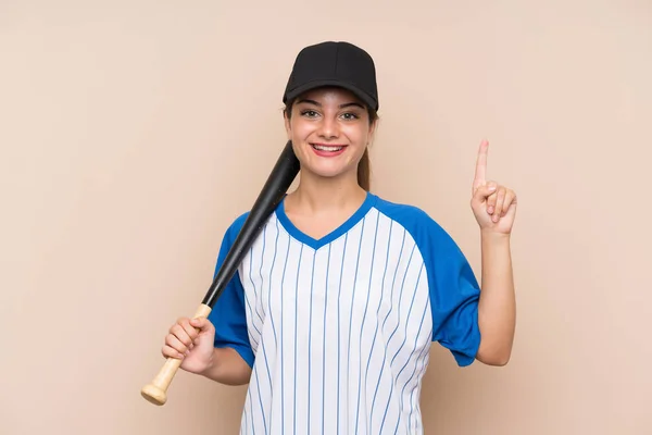 Young girl playing baseball over isolated background pointing up a great idea