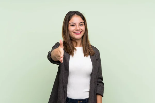 Jong Brunette Meisje Met Blazer Geïsoleerde Groene Achtergrond Schudden Handen — Stockfoto