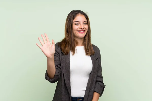 Jong Brunette Meisje Met Blazer Geïsoleerde Groene Achtergrond Salueren Met — Stockfoto