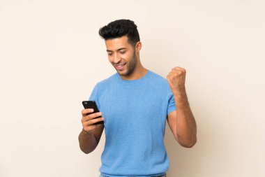 Galibiyet pozisyonunda telefonla izole edilmiş genç yakışıklı bir adam.