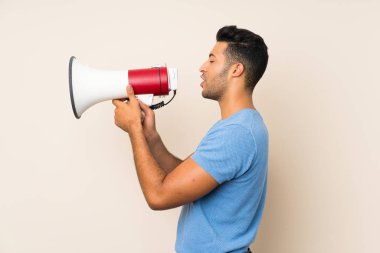 Izole arka plan üzerinde genç yakışıklı adam bir megafon ile bağırıyor