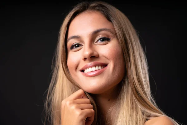 Young blonde woman over isolated black background — Stock Photo, Image