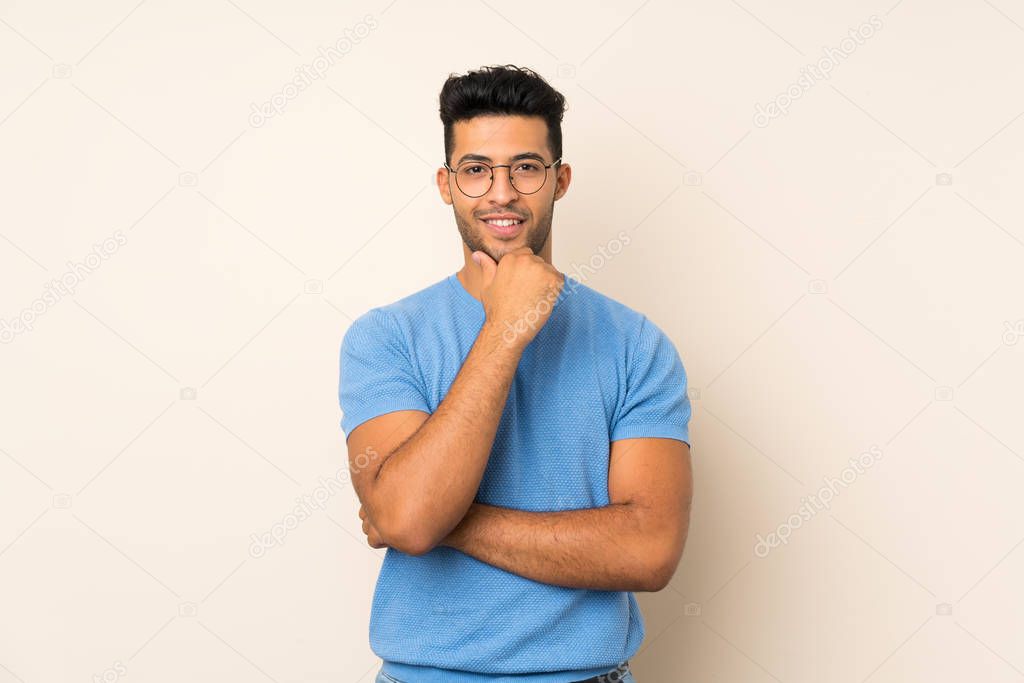 Young handsome man over isolated background with glasses and smiling