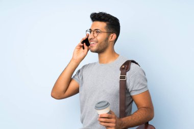 Izole arka plan üzerinde genç yakışıklı adam uzak ve bir cep almak için kahve tutarak