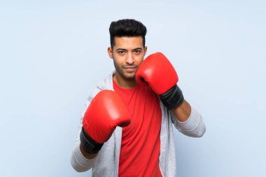 Izole mavi duvar üzerinde boks eldiven ile Spor adam