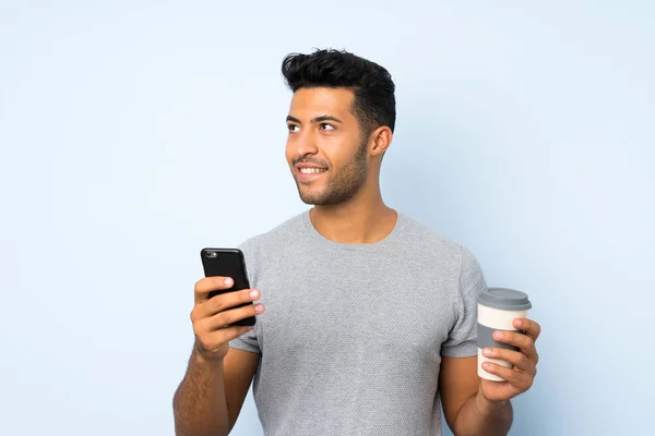 Junger Gutaussehender Mann Über Isoliertem Hintergrund Mit Kaffee Zum Mitnehmen — Stockfoto