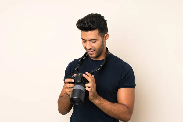 Joven Hombre Guapo Sobre Fondo Aislado Con Una Cámara Profesional — Foto de Stock