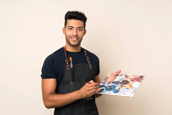 Joven Hombre Guapo Sobre Fondo Aislado Sosteniendo Una Paleta — Foto de Stock