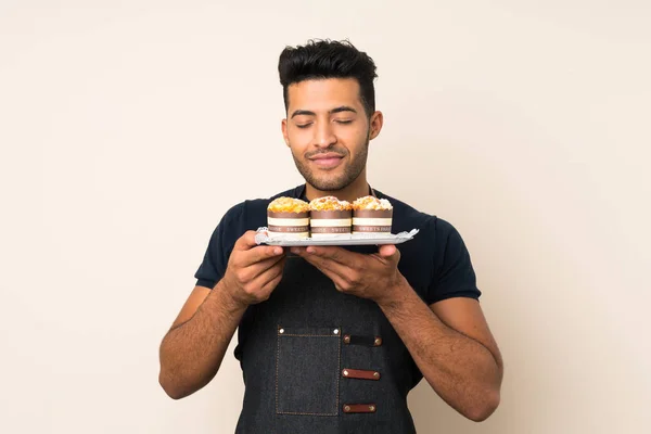 Junger Gutaussehender Mann Über Isoliertem Hintergrund Der Mini Kuchen Hält — Stockfoto