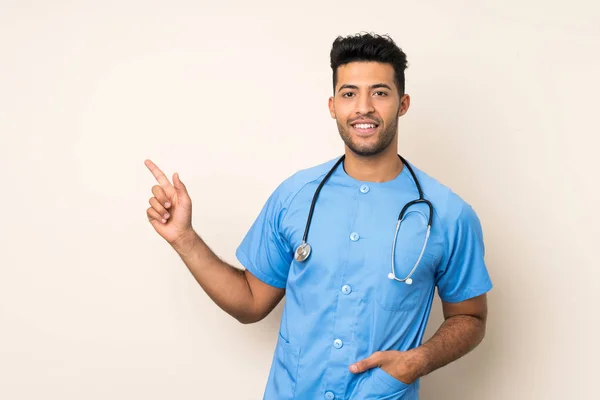 Jovem Bonito Homem Sobre Isolado Fundo Com Médico Vestido Apontando — Fotografia de Stock