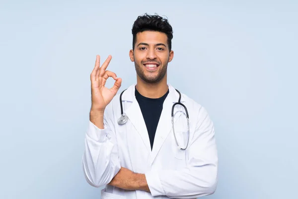 Joven Doctor Hombre Sobre Aislado Azul Pared Mostrando Signo Con —  Fotos de Stock