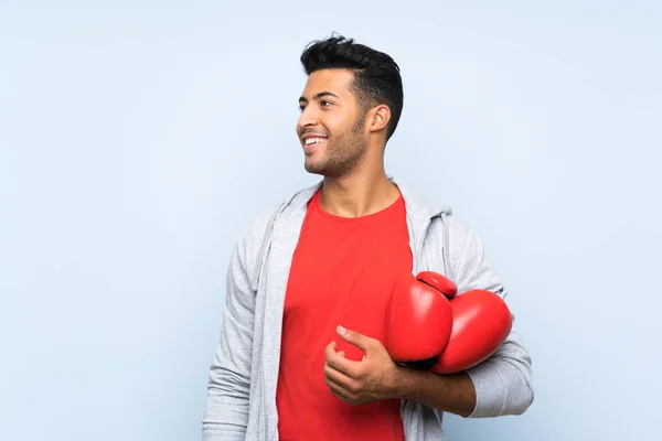 Sportmann mit Boxhandschuhen über isolierter blauer Wand — Stockfoto