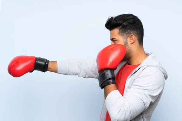 Uomo sportivo con guantoni da boxe sopra isolato muro blu — Foto Stock